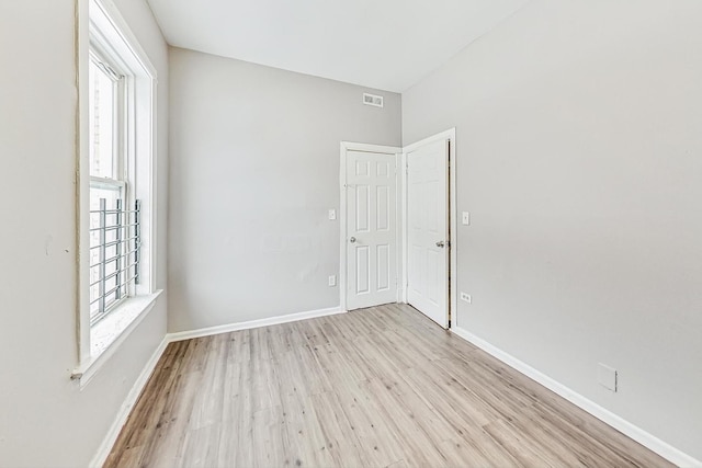 unfurnished room with light wood-type flooring and plenty of natural light