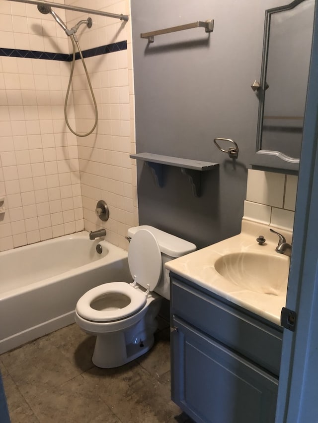 full bathroom with toilet, vanity, and tiled shower / bath