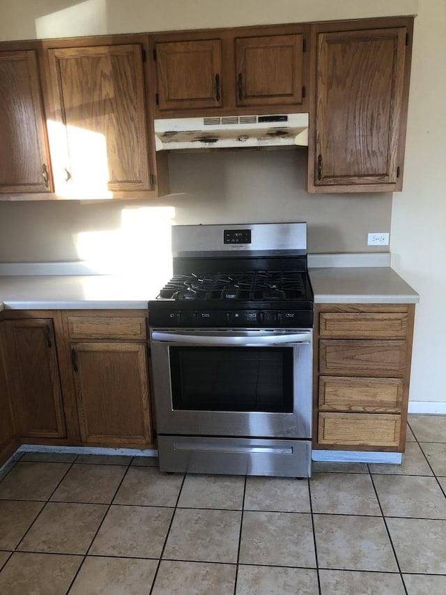 kitchen with light tile patterned flooring and stainless steel range with gas stovetop