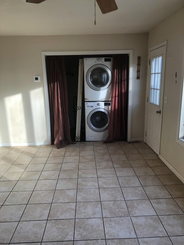 laundry area with ceiling fan, light tile patterned floors, and stacked washer / dryer