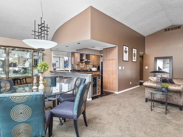 carpeted dining area featuring lofted ceiling and beverage cooler