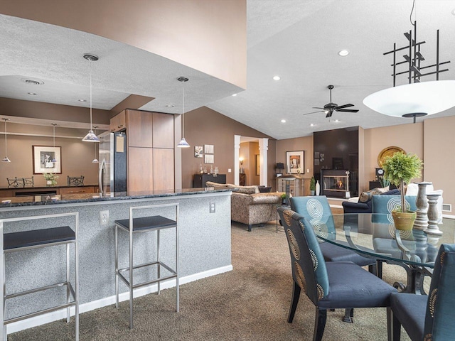 carpeted dining area with lofted ceiling, a textured ceiling, and ceiling fan