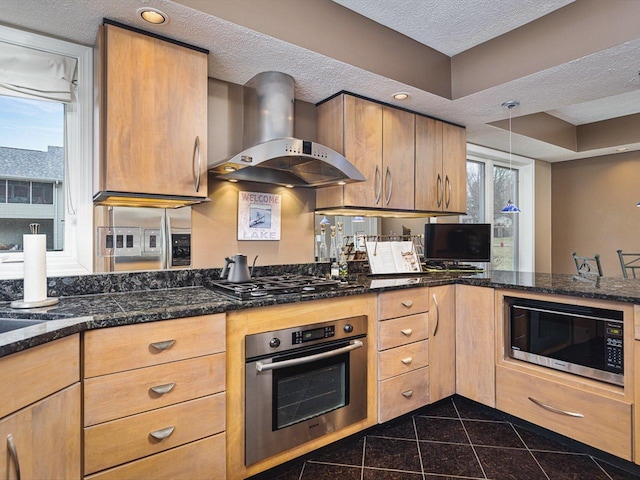 kitchen with a textured ceiling, dark stone countertops, extractor fan, pendant lighting, and appliances with stainless steel finishes