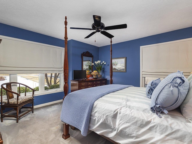 bedroom with carpet floors, ceiling fan, and a textured ceiling