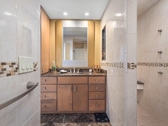 bathroom featuring tile walls, walk in shower, and vanity