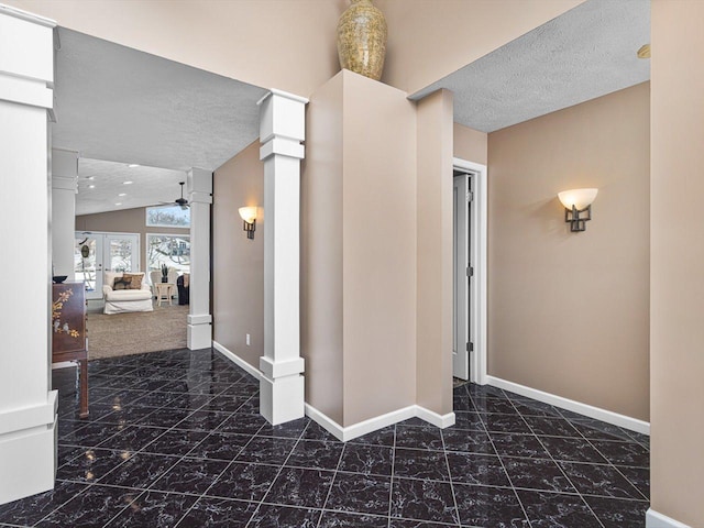 hall with a textured ceiling, french doors, and vaulted ceiling