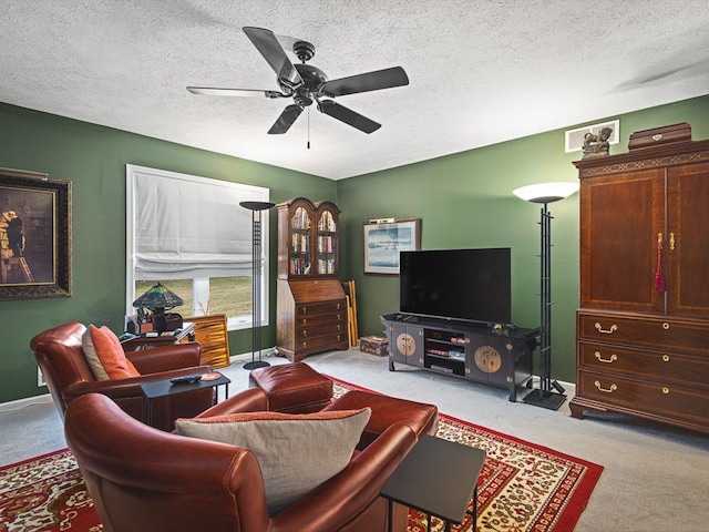 living room featuring a textured ceiling, ceiling fan, and light carpet