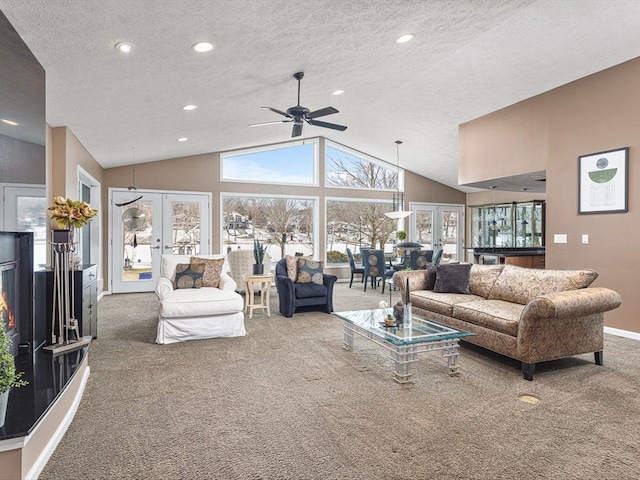 living room with a textured ceiling, a high ceiling, french doors, carpet floors, and ceiling fan