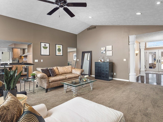 carpeted living room featuring lofted ceiling, decorative columns, a textured ceiling, and ceiling fan