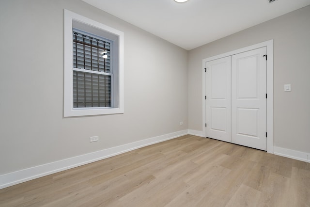 unfurnished bedroom featuring a closet and light hardwood / wood-style flooring