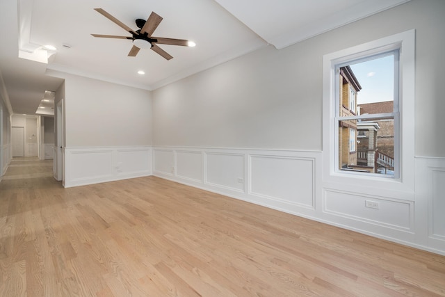 spare room featuring light wood-type flooring, ceiling fan, and ornamental molding