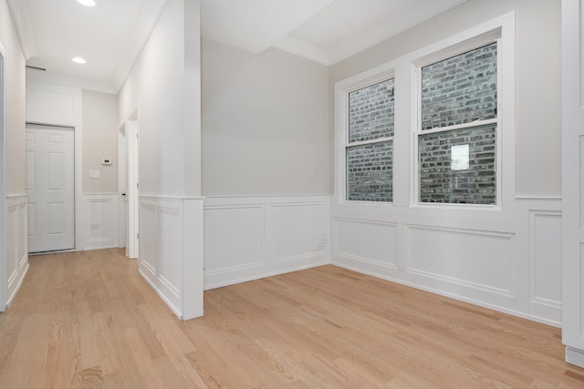 spare room featuring light wood-type flooring and ornamental molding