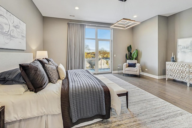 bedroom featuring access to outside, a chandelier, and hardwood / wood-style floors