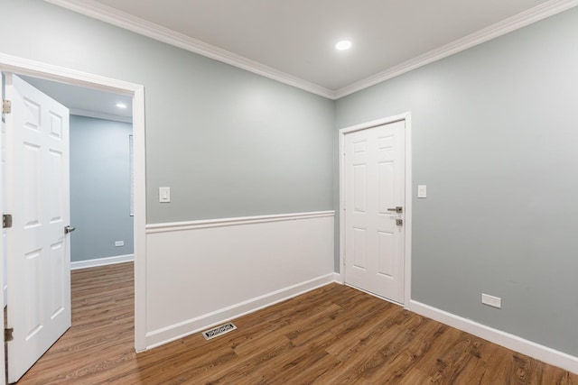 empty room with hardwood / wood-style floors and ornamental molding