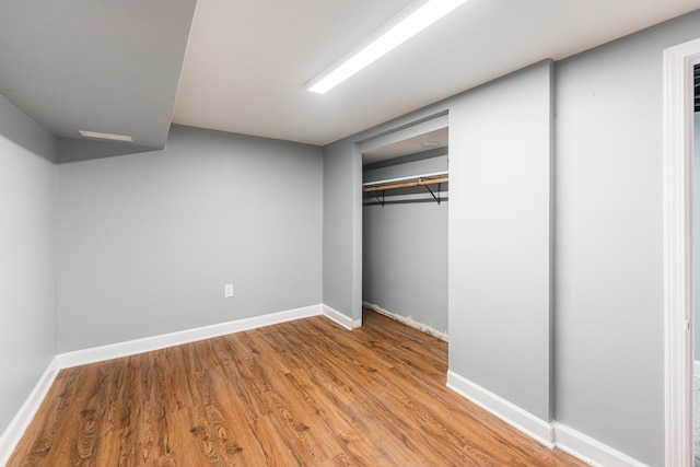 unfurnished bedroom with light hardwood / wood-style flooring and a closet