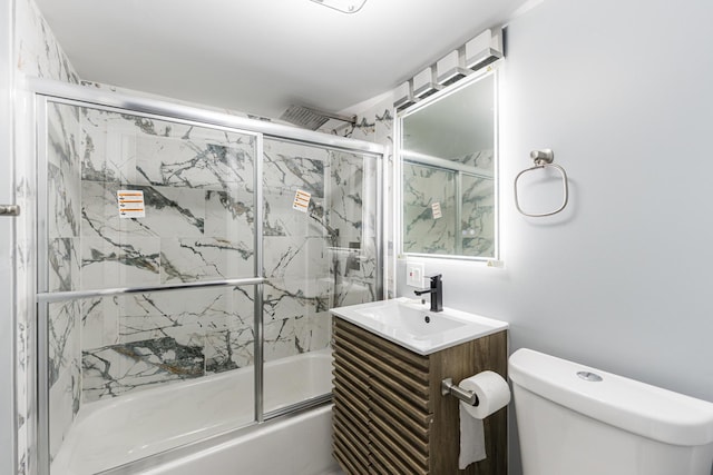 full bathroom with shower / bath combination with glass door, vanity, and toilet