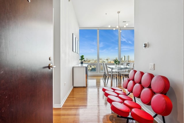 interior space featuring light hardwood / wood-style flooring, expansive windows, and a notable chandelier