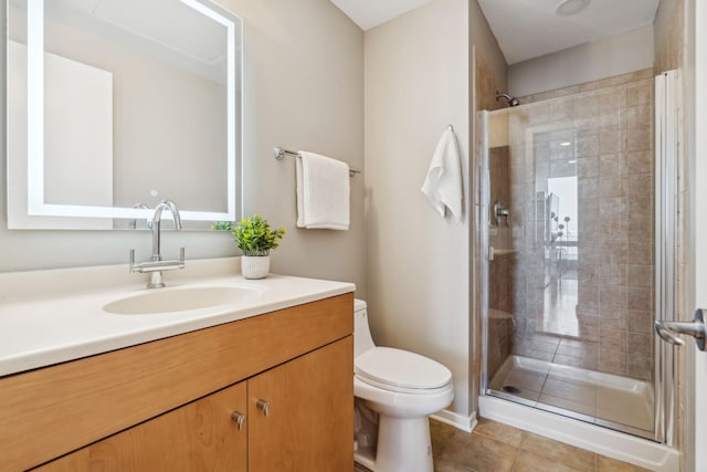 bathroom with tile patterned flooring, vanity, an enclosed shower, and toilet