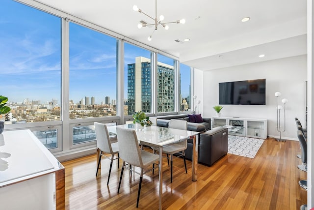 dining room with a chandelier, hardwood / wood-style flooring, and expansive windows