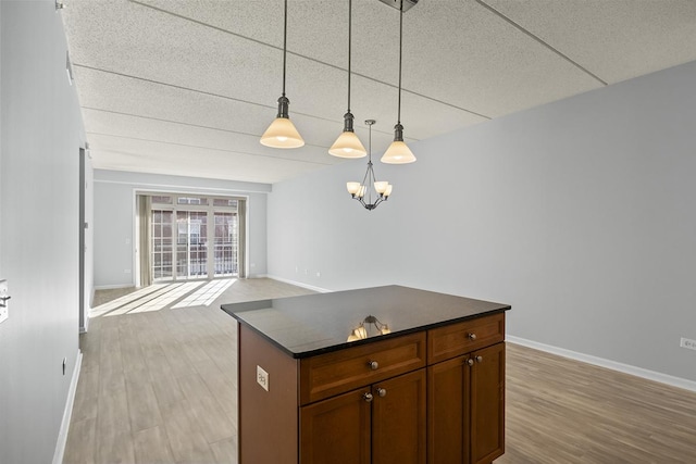 kitchen featuring hanging light fixtures, a notable chandelier, and light wood-type flooring