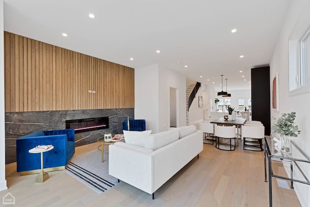 living room featuring light wood-type flooring and a fireplace