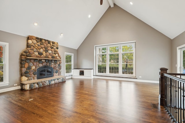 living room with beam ceiling, a fireplace, baseboards, and wood finished floors