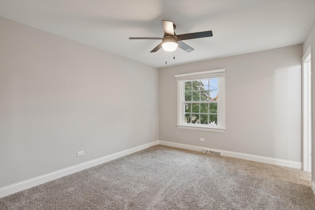 carpeted empty room featuring visible vents, ceiling fan, and baseboards