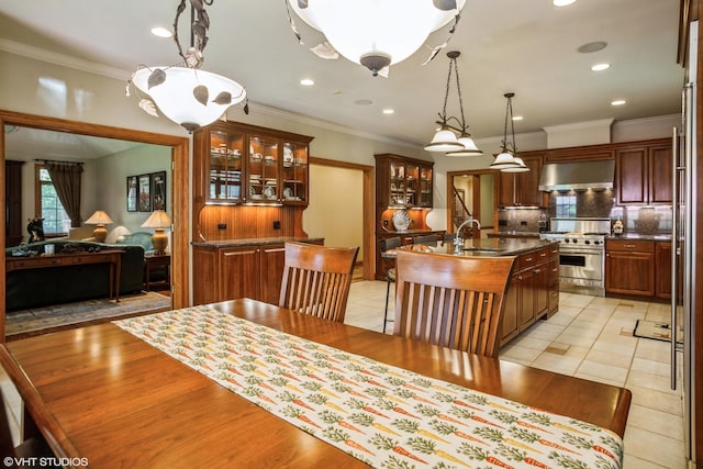 dining room with sink, ornamental molding, and light tile patterned floors