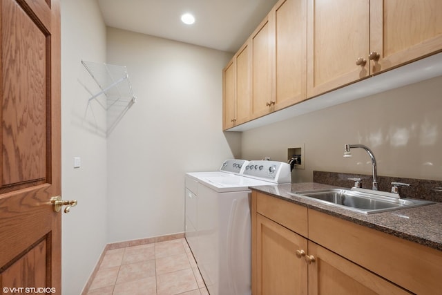 laundry room with sink, washing machine and clothes dryer, light tile patterned floors, and cabinets