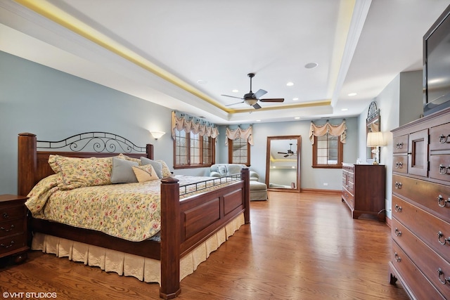 bedroom featuring ceiling fan, a raised ceiling, and hardwood / wood-style flooring