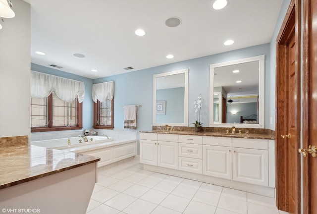 bathroom featuring ceiling fan, a washtub, tile patterned flooring, and vanity