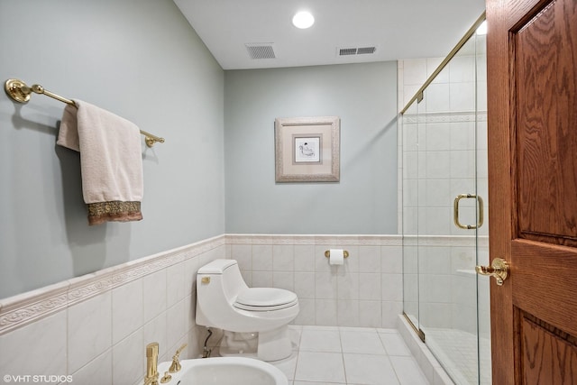 bathroom featuring a bidet, tile patterned floors, a shower with shower door, and toilet