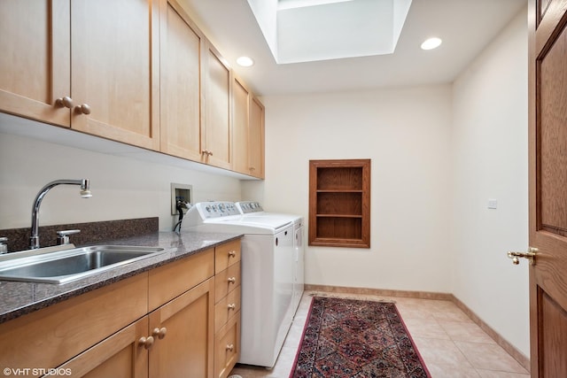 washroom featuring washer and clothes dryer, light tile patterned floors, cabinets, a skylight, and sink