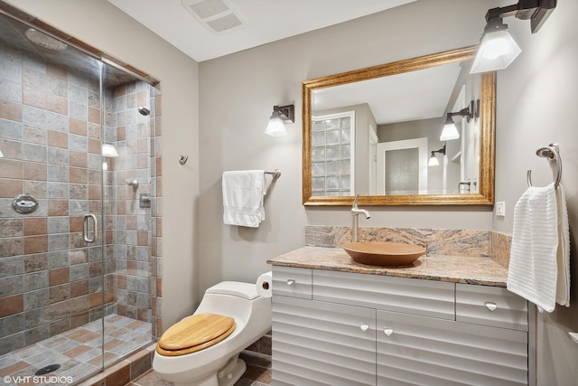 bathroom with walk in shower, vanity, and toilet