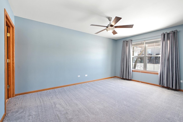 carpeted spare room featuring ceiling fan