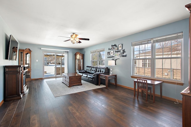 living room with ceiling fan, dark wood-type flooring, and plenty of natural light