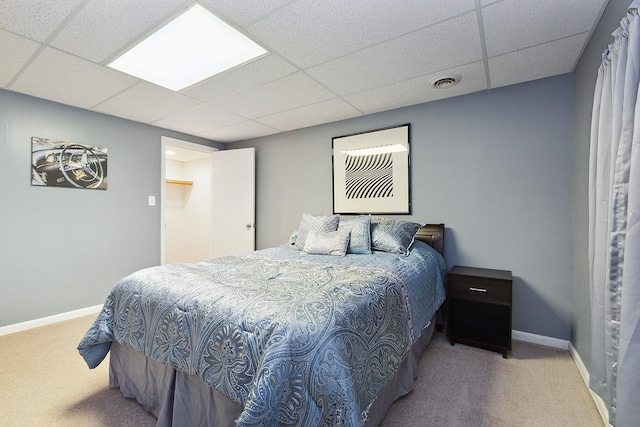 bedroom featuring a drop ceiling and light carpet