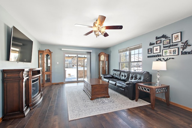 living room featuring ceiling fan, dark wood-type flooring, and plenty of natural light