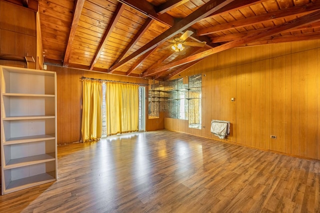 empty room featuring vaulted ceiling with beams, wooden walls, wooden ceiling, and wood-type flooring