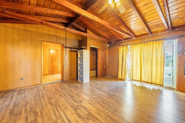 interior space featuring vaulted ceiling with beams, light hardwood / wood-style flooring, wood walls, and wood ceiling