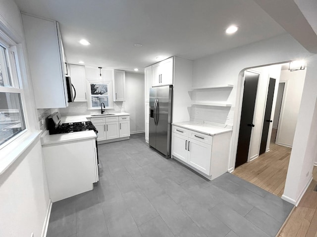 kitchen featuring white cabinets, sink, appliances with stainless steel finishes, and tasteful backsplash