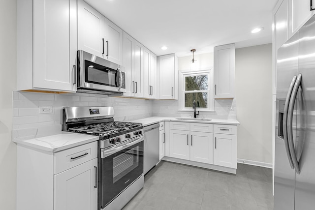 kitchen with stainless steel appliances, white cabinetry, and sink