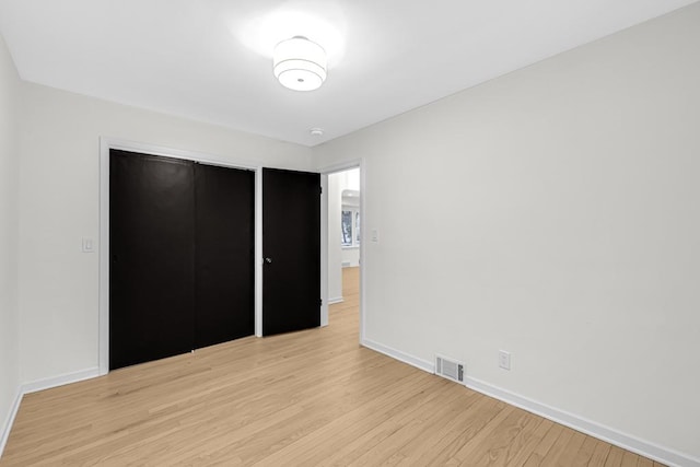 unfurnished bedroom with a closet and light hardwood / wood-style floors