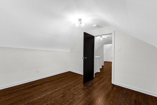 bonus room with vaulted ceiling and dark wood-type flooring