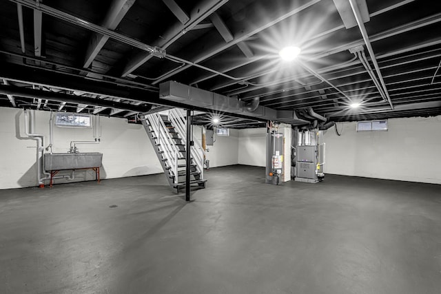 basement featuring electric panel, gas water heater, heating unit, and sink