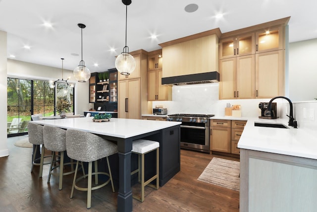 kitchen featuring a kitchen island, premium range hood, light countertops, high end stainless steel range, and a sink