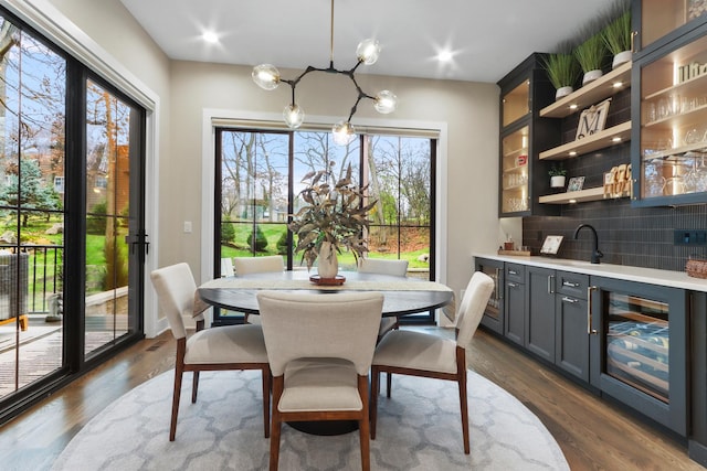 dining room featuring dark wood finished floors, beverage cooler, and indoor wet bar