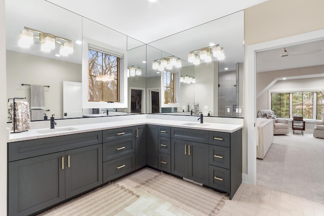 bathroom featuring a sink, double vanity, and a tile shower