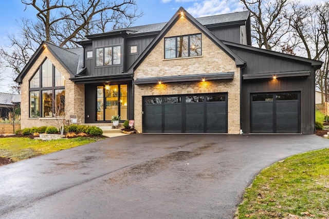 view of front of home featuring brick siding, board and batten siding, and driveway