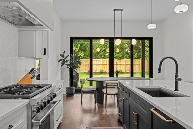 328 S Loomis St, Naperville, IL 60540 - kitchen featuring wall chimney exhaust hood, high end stove, dark wood-style flooring, decorative light fixtures, and light stone counters